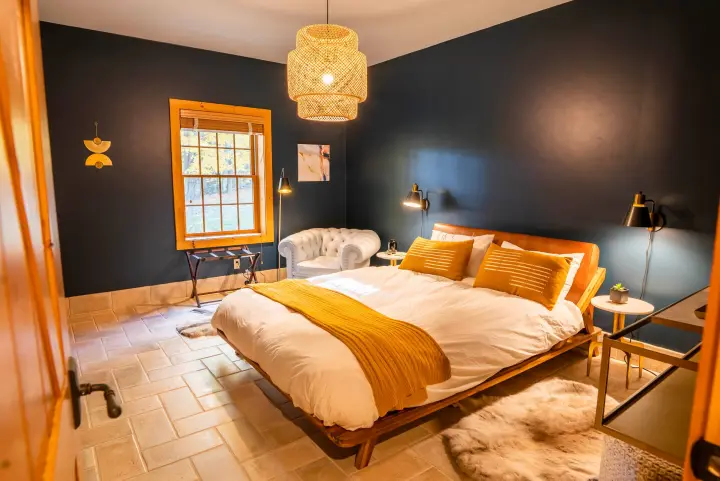 Our guest bedroom on the lower floor charms with its moody walls and elegant leather finishes.